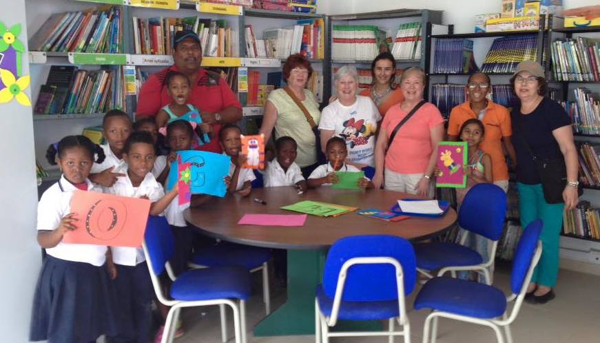 Columbia project volunteers with children in the library